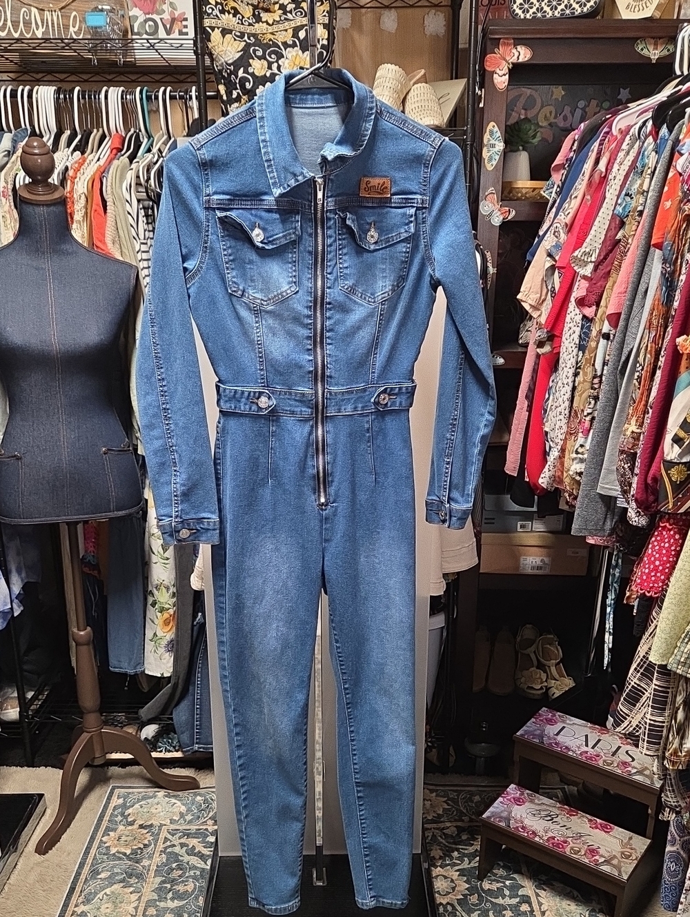 Blue long-sleeve denim utility jumpsuit featuring a front zip